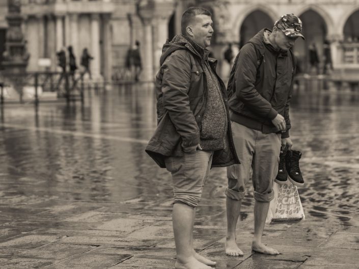 Two men barefoot because of flooding