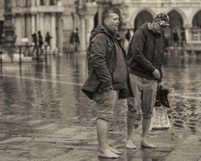 Two men barefoot because of flooding