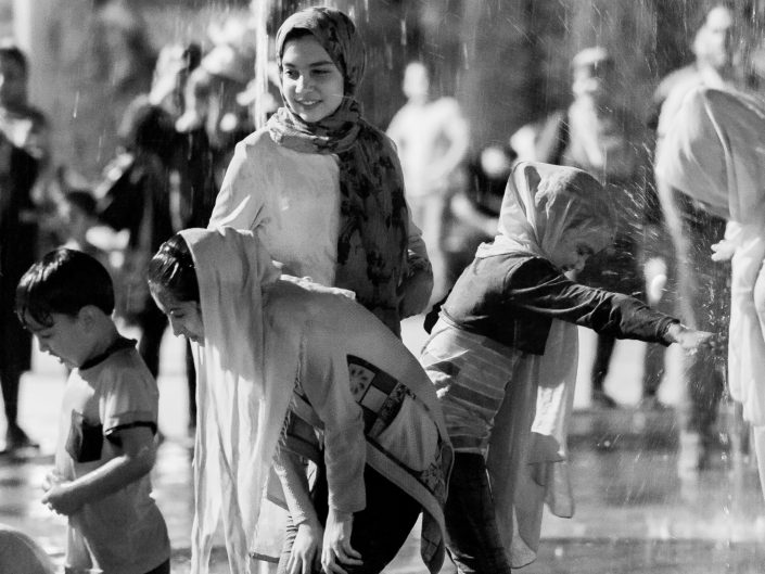 Children wet at night playing with water, Tehran