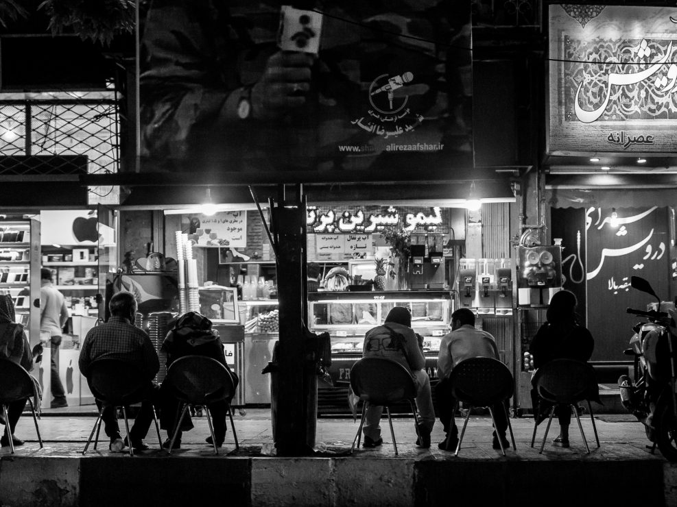Tehran by night, group of people sitting front of shop