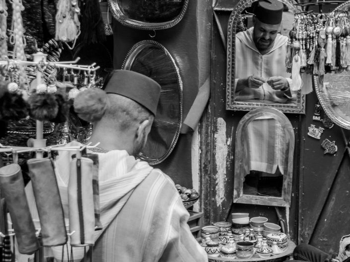 Fez merchant reflected in mirror, Morocco