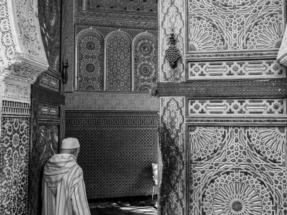 Old man wearing kaftan entering mosque, Fez
