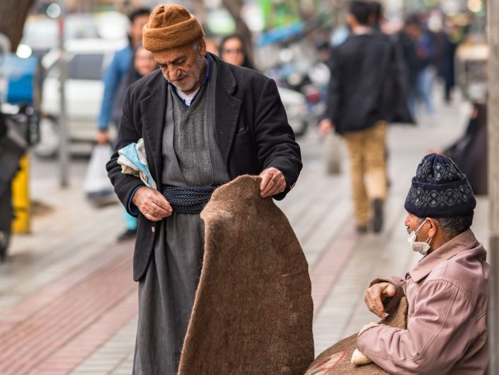 Man shopping a carpet from a street vendor