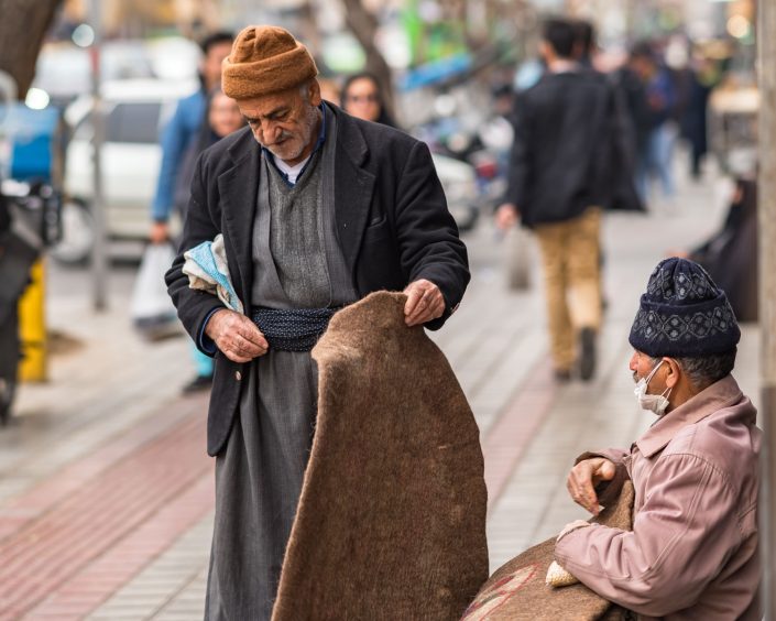 Man shopping a carpet from a street vendor
