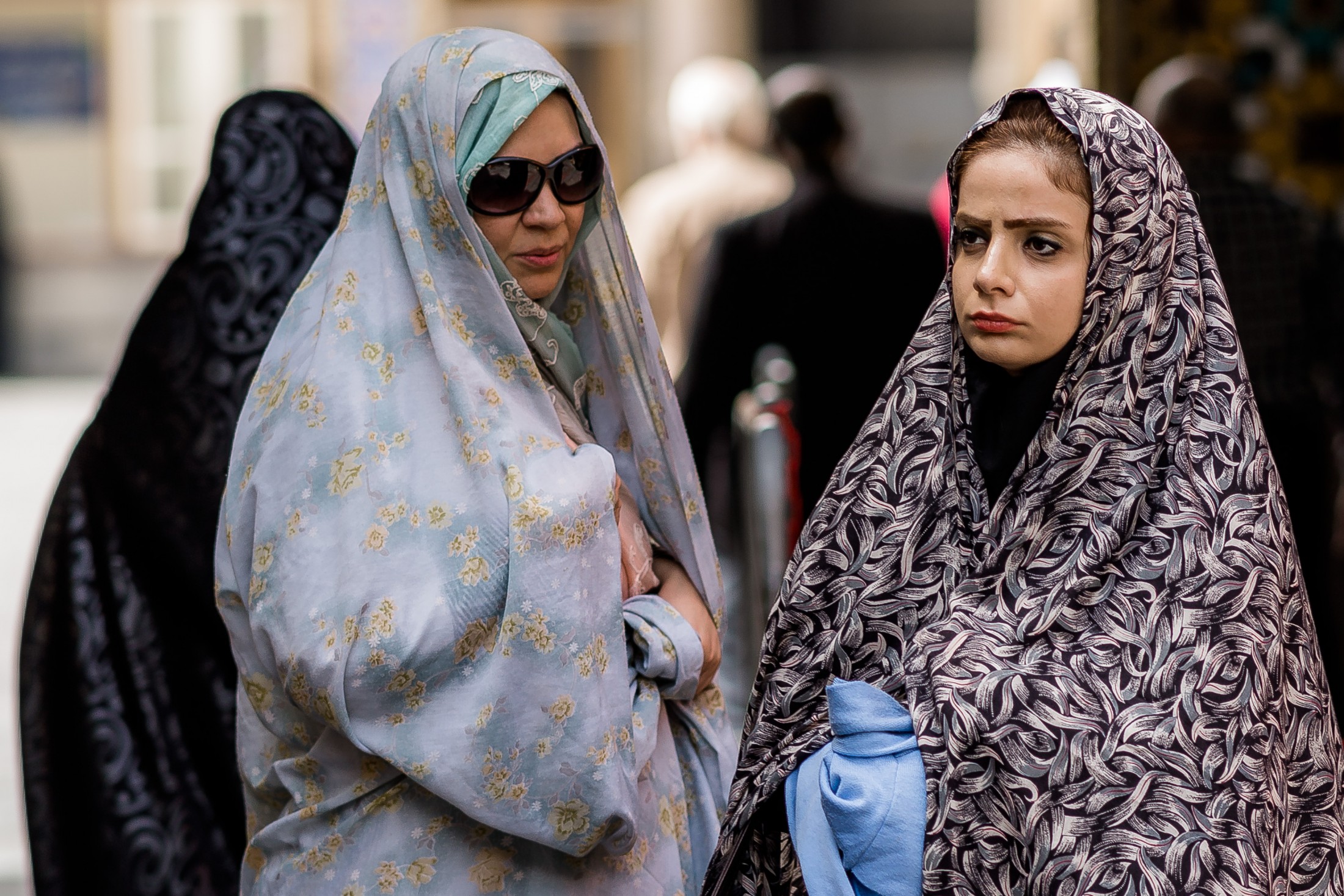 Mother and teenage daughter wearing chadors outside a mosque, Iran
